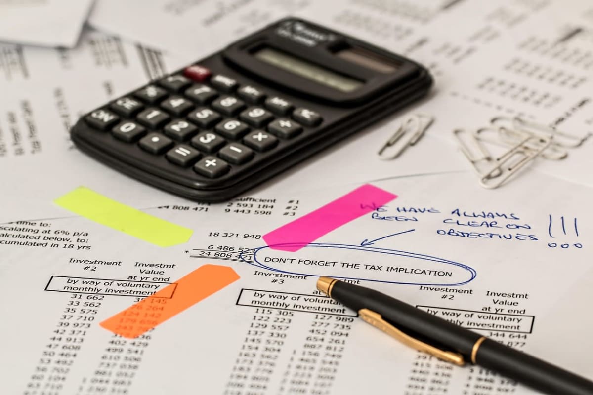 calculator with euro coins on a tax form and pen, desk closeup