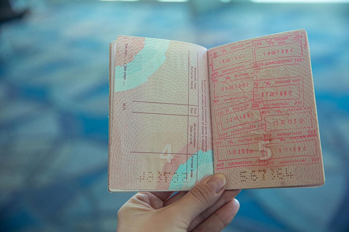 open passport with travel and visa stamps on display, close-up of pages