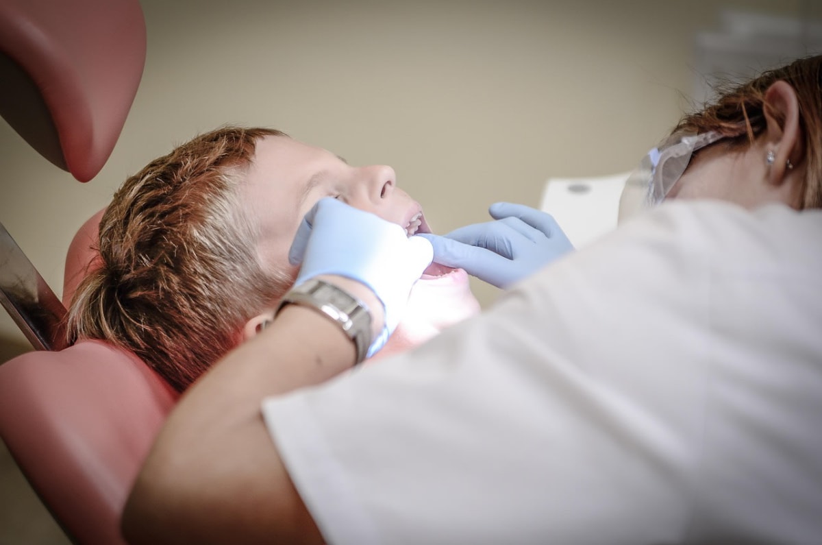dentist examining patient in dental chair, clinical lighting, German clinic