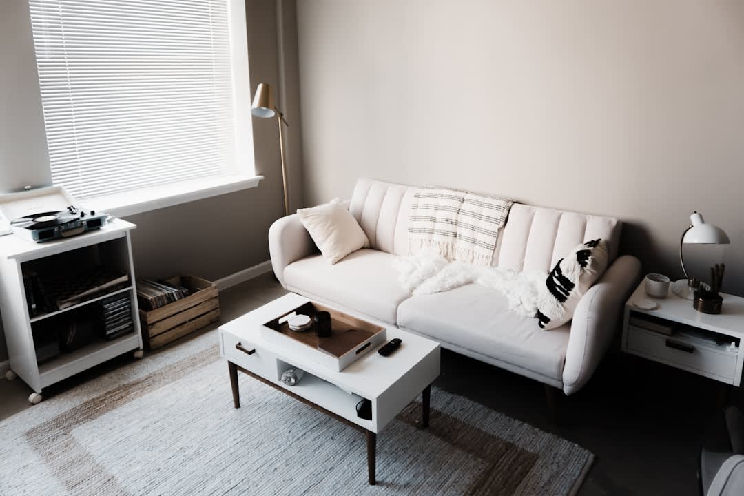 messy couch with rumpled blanket and pillow in a small Berlin living room, daylight
